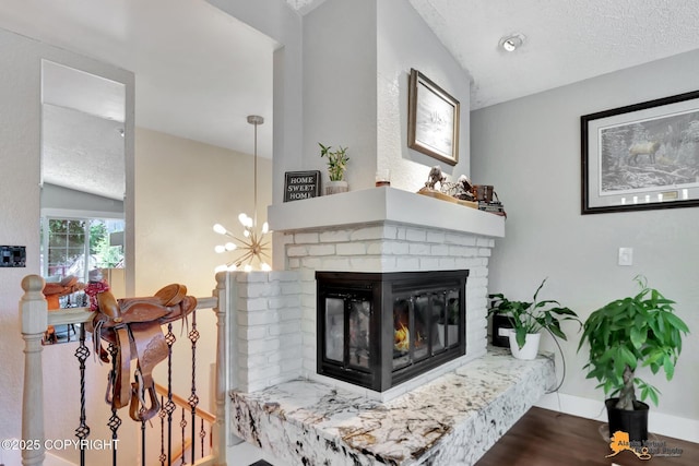2309 Success Dr, Anchorage, AK 99504 - detailed view of a textured ceiling, wood finished floors, a fireplace, and a chandelier