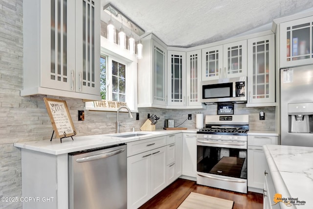 2309 Success Dr, Anchorage, AK 99504 - kitchen with stainless steel appliances, a textured ceiling, tasteful backsplash, light stone countertops, and white cabinetry