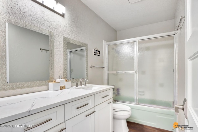 2309 Success Dr, Anchorage, AK 99504 - full bathroom with vanity, wood finished floors, enclosed tub / shower combo, and a textured wall