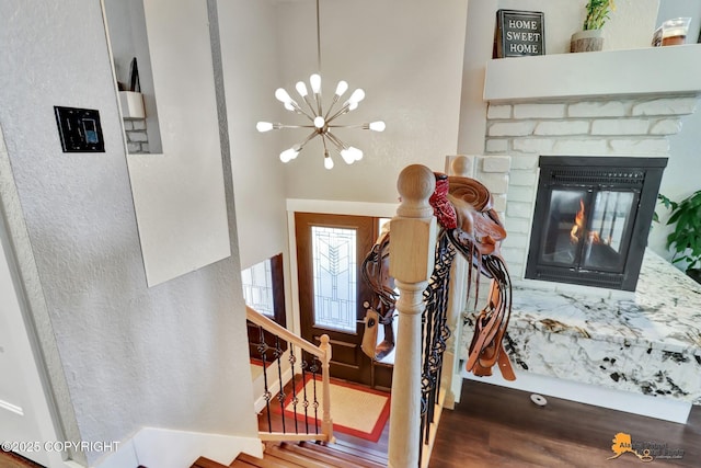 2309 Success Dr, Anchorage, AK 99504 - foyer featuring wood finished floors, a chandelier, stairway, and a glass covered fireplace