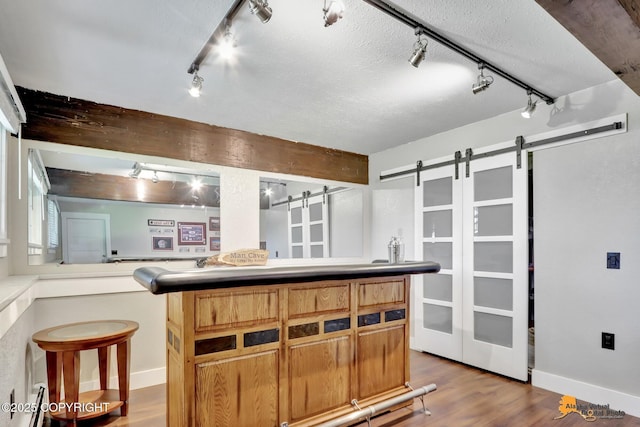 2309 Success Dr, Anchorage, AK 99504 - kitchen with rail lighting, a barn door, wood finished floors, and a textured ceiling