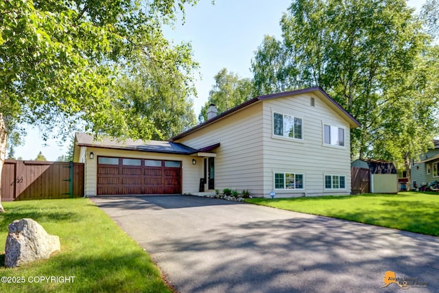 2309 Success Dr, Anchorage, AK 99504 - tri-level home with driveway, an attached garage, a chimney, and a gate