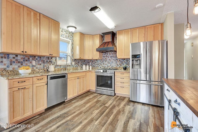 8630 E 17th Ave, Anchorage, AK 99504 - kitchen with appliances with stainless steel finishes, custom exhaust hood, light brown cabinetry, wood finished floors, and a textured ceiling