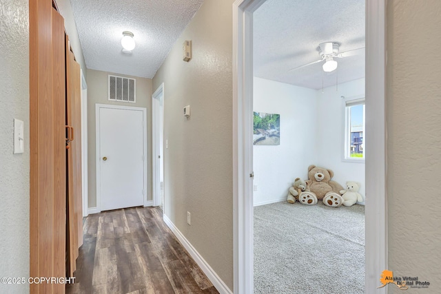 8630 E 17th Ave, Anchorage, AK 99504 - hallway featuring a textured ceiling, a textured wall, and dark wood-style flooring