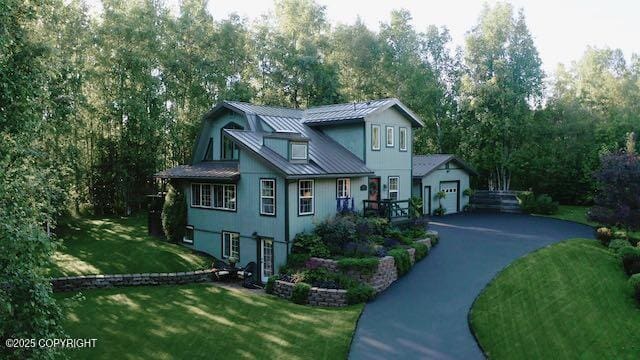 21212 Rock Ptarmigan St, Chugiak, AK 99567 - view of front of property featuring driveway, a front lawn, a metal roof, view of wooded area, and a standing seam roof