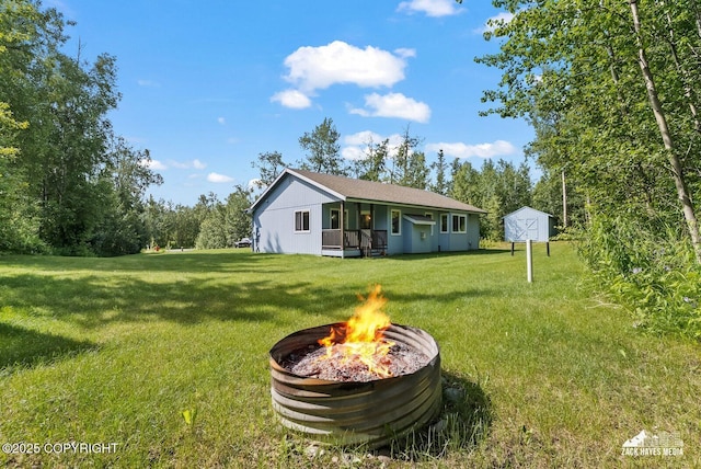 7595 E Breckenridge Dr, Wasilla, AK 99654 - view of green lawn featuring an outdoor fire pit and a storage shed