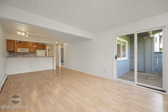 1675 Sitka St # 102, Anchorage, AK 99501 - unfurnished living room featuring light wood-type flooring and a textured ceiling