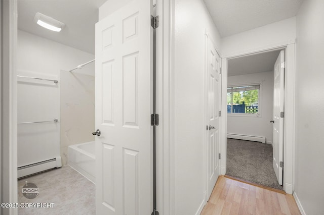 1675 Sitka St # 102, Anchorage, AK 99501 - full bathroom with a baseboard heating unit, baseboard heating, shower / bathtub combination, and wood finished floors