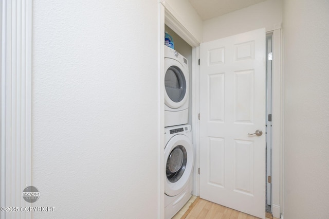 1675 Sitka St # 102, Anchorage, AK 99501 - washroom with stacked washer and clothes dryer and light wood-style flooring