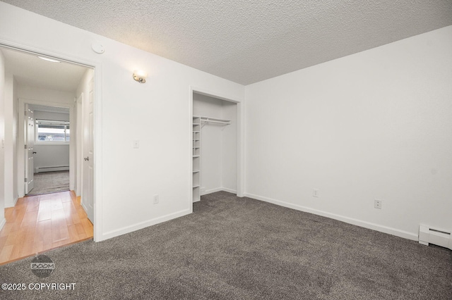 1675 Sitka St # 102, Anchorage, AK 99501 - unfurnished bedroom with a baseboard heating unit, carpet, a baseboard radiator, a closet, and a textured ceiling