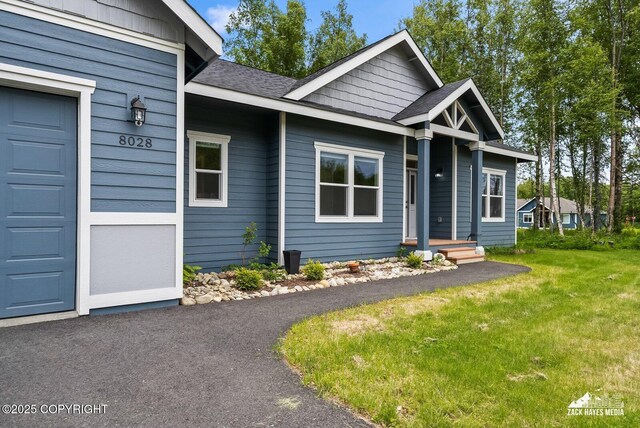 8028 E Yarn Spinner Cir, Palmer, AK 99645 - view of front of home with a front lawn, a shingled roof, and a garage