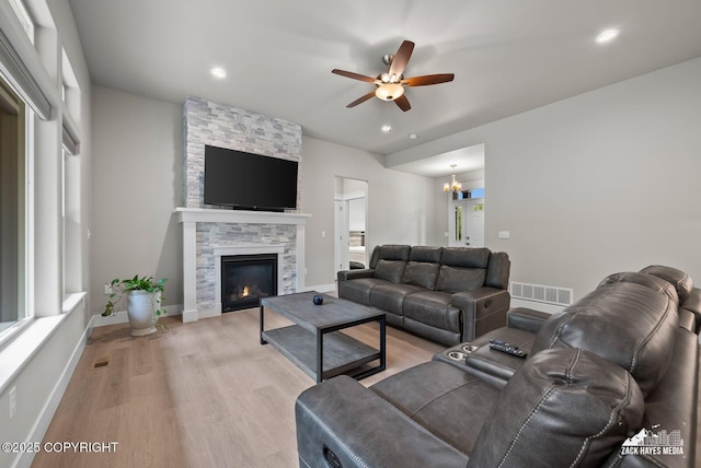 8028 E Yarn Spinner Cir, Palmer, AK 99645 - living room featuring light wood finished floors, a ceiling fan, a fireplace, recessed lighting, and a chandelier