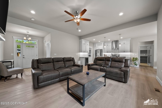 8028 E Yarn Spinner Cir, Palmer, AK 99645 - living room featuring light wood-style floors, a chandelier, ceiling fan, recessed lighting, and beverage cooler