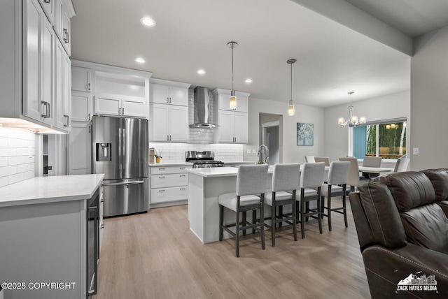 8028 E Yarn Spinner Cir, Palmer, AK 99645 - kitchen featuring appliances with stainless steel finishes, wall chimney exhaust hood, open floor plan, light countertops, and recessed lighting