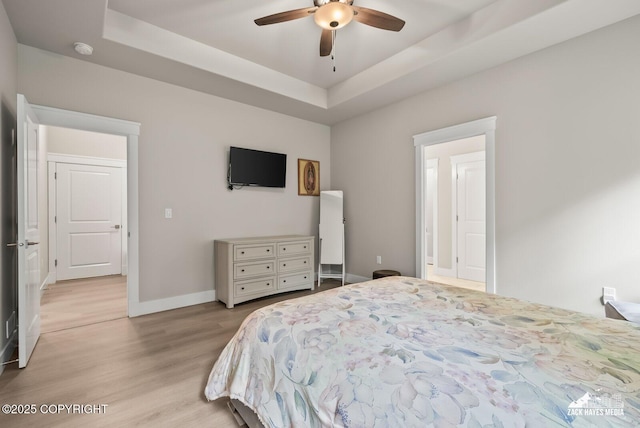 8028 E Yarn Spinner Cir, Palmer, AK 99645 - bedroom with light wood-style floors, a tray ceiling, and a ceiling fan