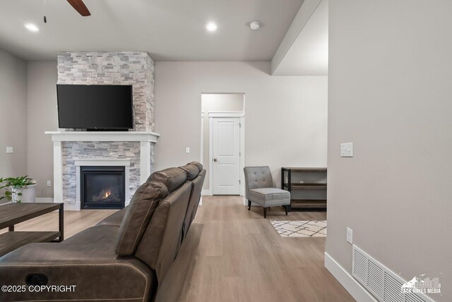 8028 E Yarn Spinner Cir, Palmer, AK 99645 - living area with light wood-style floors, a stone fireplace, ceiling fan, and recessed lighting