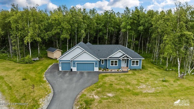 8028 E Yarn Spinner Cir, Palmer, AK 99645 - view of front of property with an attached garage, driveway, a front lawn, and an outbuilding