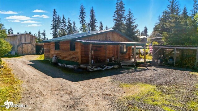 71252 Siri, Anchor Point, AK 99556 - view of property exterior featuring a porch, a metal roof, and an outdoor structure