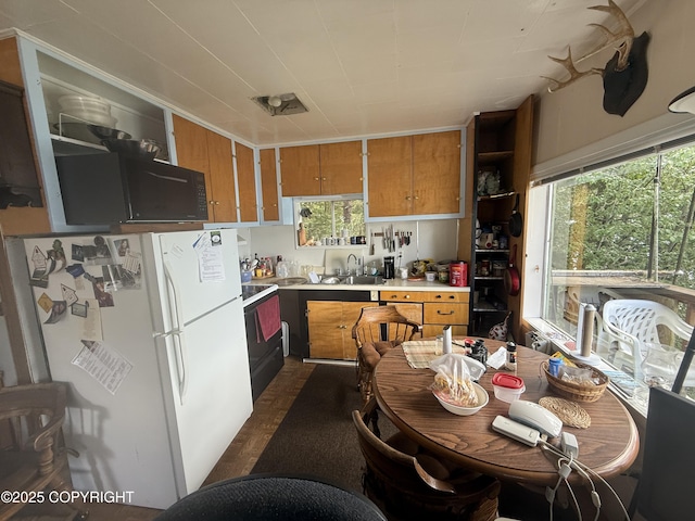 406 Mitkof Hwy, Petersburg, AK 99833 - kitchen featuring freestanding refrigerator, brown cabinets, light countertops, and electric range
