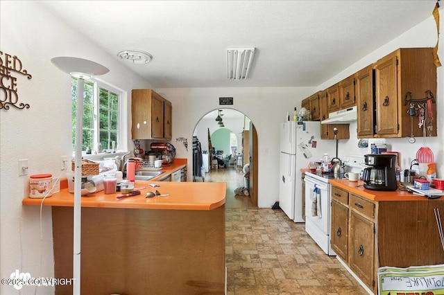 701 N Luke St, Wasilla, AK 99654 - kitchen featuring electric stove, under cabinet range hood, stone finish flooring, a peninsula, and brown cabinetry