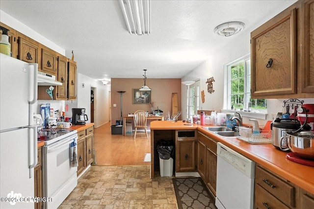 701 N Luke St, Wasilla, AK 99654 - kitchen featuring white appliances, brown cabinets, light countertops, a peninsula, and under cabinet range hood