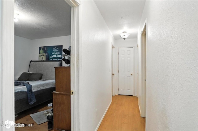 701 N Luke St, Wasilla, AK 99654 - hall featuring wood finished floors, a textured wall, and a textured ceiling