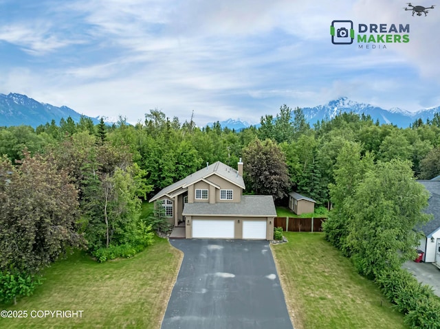 11240 E Equestrian St, Palmer, AK 99645 - view of front of property with asphalt driveway, a mountain view, a garage, a chimney, and a view of trees