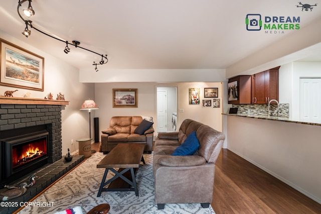11240 E Equestrian St, Palmer, AK 99645 - living room with rail lighting, wood finished floors, and a brick fireplace
