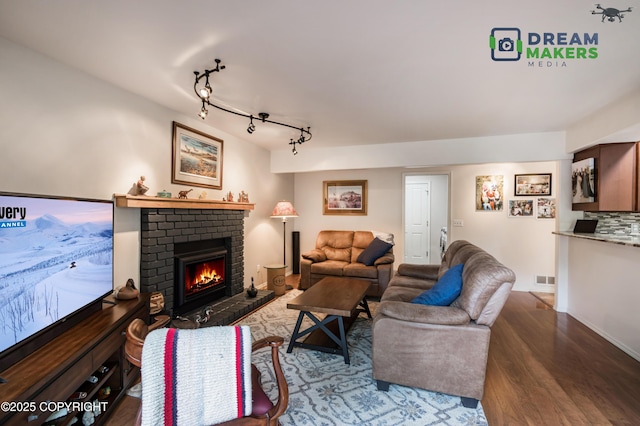 11240 E Equestrian St, Palmer, AK 99645 - living area featuring a brick fireplace, wood finished floors, and rail lighting