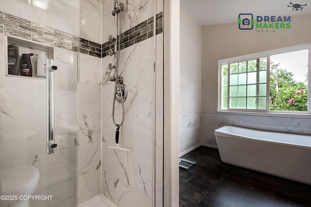 11240 E Equestrian St, Palmer, AK 99645 - full bathroom with a freestanding tub, a marble finish shower, a wainscoted wall, and tile walls