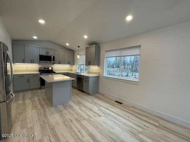 2033 E Chickaloon Rd, Wasilla, AK 99654 - kitchen with stainless steel appliances, gray cabinets, a kitchen island, light countertops, and light wood-style floors