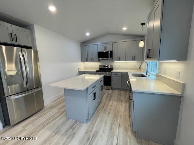 2033 E Chickaloon Rd, Wasilla, AK 99654 - kitchen with stainless steel appliances, a kitchen island, gray cabinetry, light wood-style floors, and light stone countertops