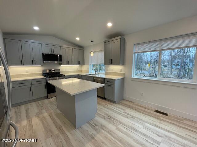 2033 E Chickaloon Rd, Wasilla, AK 99654 - kitchen with stainless steel appliances, gray cabinets, light countertops, vaulted ceiling, and recessed lighting