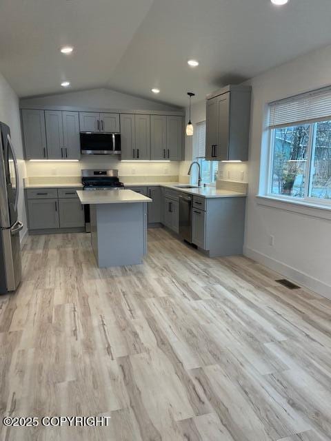 2033 E Chickaloon Rd, Wasilla, AK 99654 - kitchen with stainless steel appliances, gray cabinets, a center island, vaulted ceiling, and light countertops