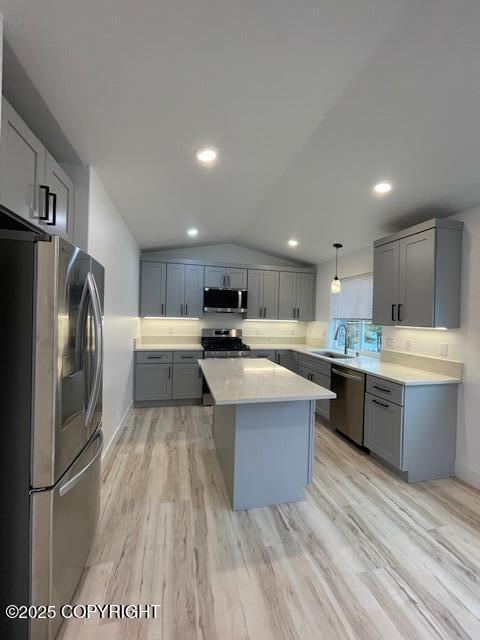 2033 E Chickaloon Rd, Wasilla, AK 99654 - kitchen with appliances with stainless steel finishes, gray cabinetry, a kitchen island, light countertops, and light wood-type flooring