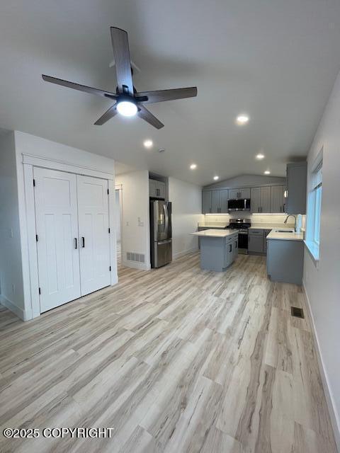 2033 E Chickaloon Rd, Wasilla, AK 99654 - kitchen with appliances with stainless steel finishes, gray cabinetry, a ceiling fan, light countertops, and a center island