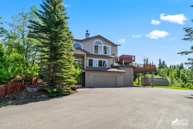 10100 Zermatt Cir, Anchorage, AK 99507 - view of front of house with asphalt driveway, an attached garage, a chimney, and a balcony