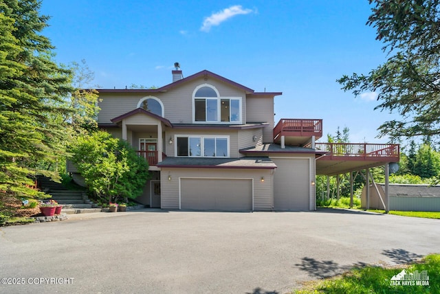 10100 Zermatt Cir, Anchorage, AK 99507 - view of front of house featuring driveway, an attached garage, a chimney, a wooden deck, and a carport