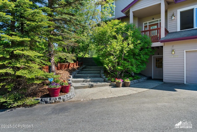 10100 Zermatt Cir, Anchorage, AK 99507 - doorway to property featuring a balcony, a garage, and a shingled roof