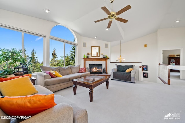 10100 Zermatt Cir, Anchorage, AK 99507 - carpeted living area featuring vaulted ceiling, a glass covered fireplace, a ceiling fan, a chandelier, and recessed lighting