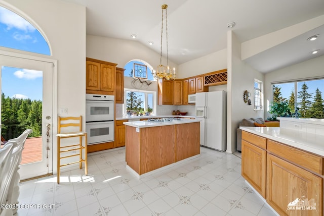 10100 Zermatt Cir, Anchorage, AK 99507 - kitchen with white appliances, a kitchen island, light countertops, a chandelier, and decorative light fixtures
