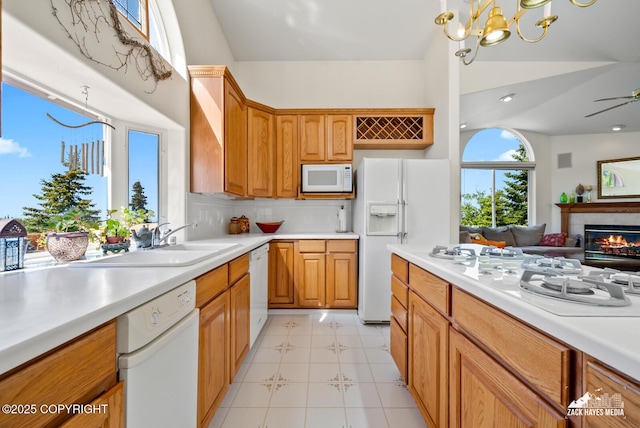 10100 Zermatt Cir, Anchorage, AK 99507 - kitchen featuring white appliances, light countertops, open floor plan, a chandelier, and a glass covered fireplace