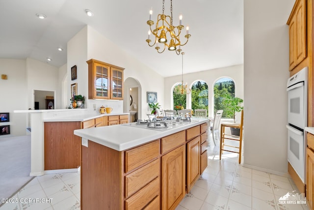 10100 Zermatt Cir, Anchorage, AK 99507 - kitchen featuring a chandelier, vaulted ceiling, white appliances, a kitchen island, and light countertops