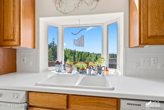 10100 Zermatt Cir, Anchorage, AK 99507 - kitchen featuring dishwasher, white dishwasher, light countertops, backsplash, and brown cabinets