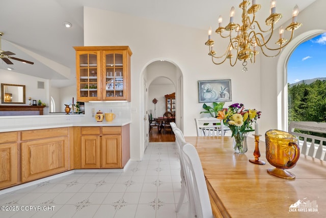 10100 Zermatt Cir, Anchorage, AK 99507 - dining area featuring arched walkways, vaulted ceiling, light flooring, ceiling fan, and a chandelier