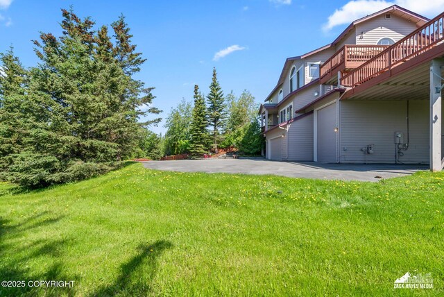 10100 Zermatt Cir, Anchorage, AK 99507 - view of grassy yard featuring a wooden deck and a garage