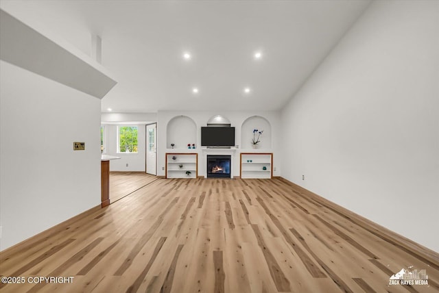 11510 Tulin Park Loop, Anchorage, AK 99516 - unfurnished living room with light wood finished floors, recessed lighting, and a glass covered fireplace