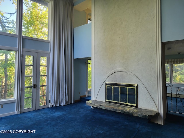 9921 Nearpoint Dr, Anchorage, AK 99507 - unfurnished living room with french doors, carpet, and a glass covered fireplace