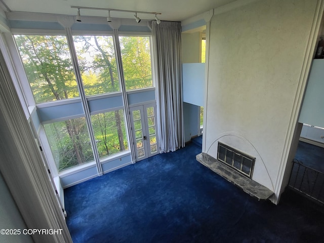 9921 Nearpoint Dr, Anchorage, AK 99507 - unfurnished living room with french doors, dark colored carpet, a glass covered fireplace, and track lighting