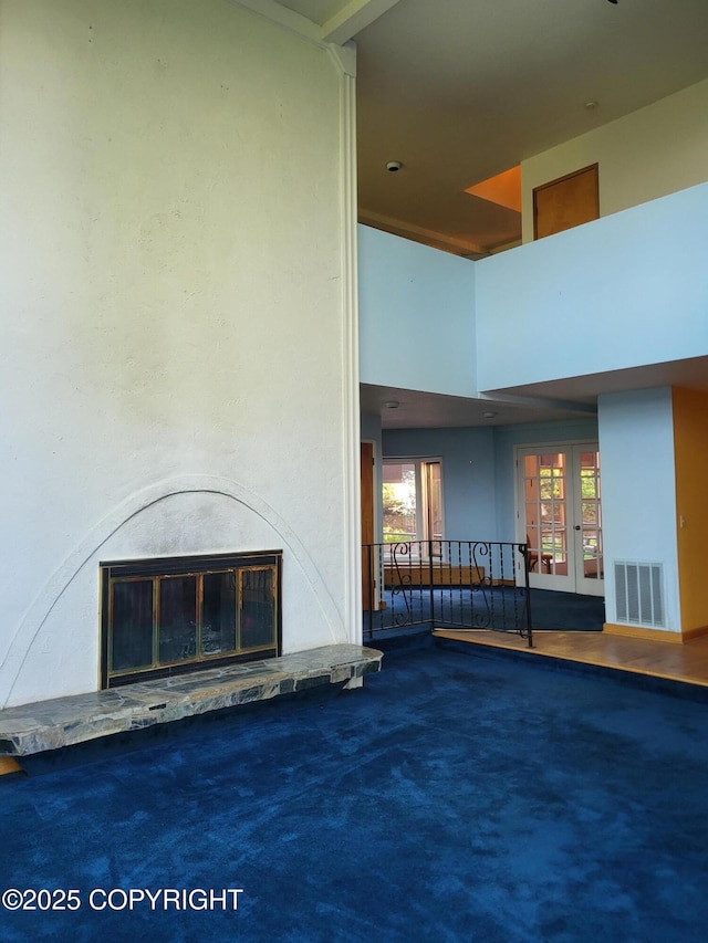 9921 Nearpoint Dr, Anchorage, AK 99507 - unfurnished living room with a glass covered fireplace, carpet floors, french doors, and a high ceiling